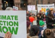 crowd holding signs about climate control 